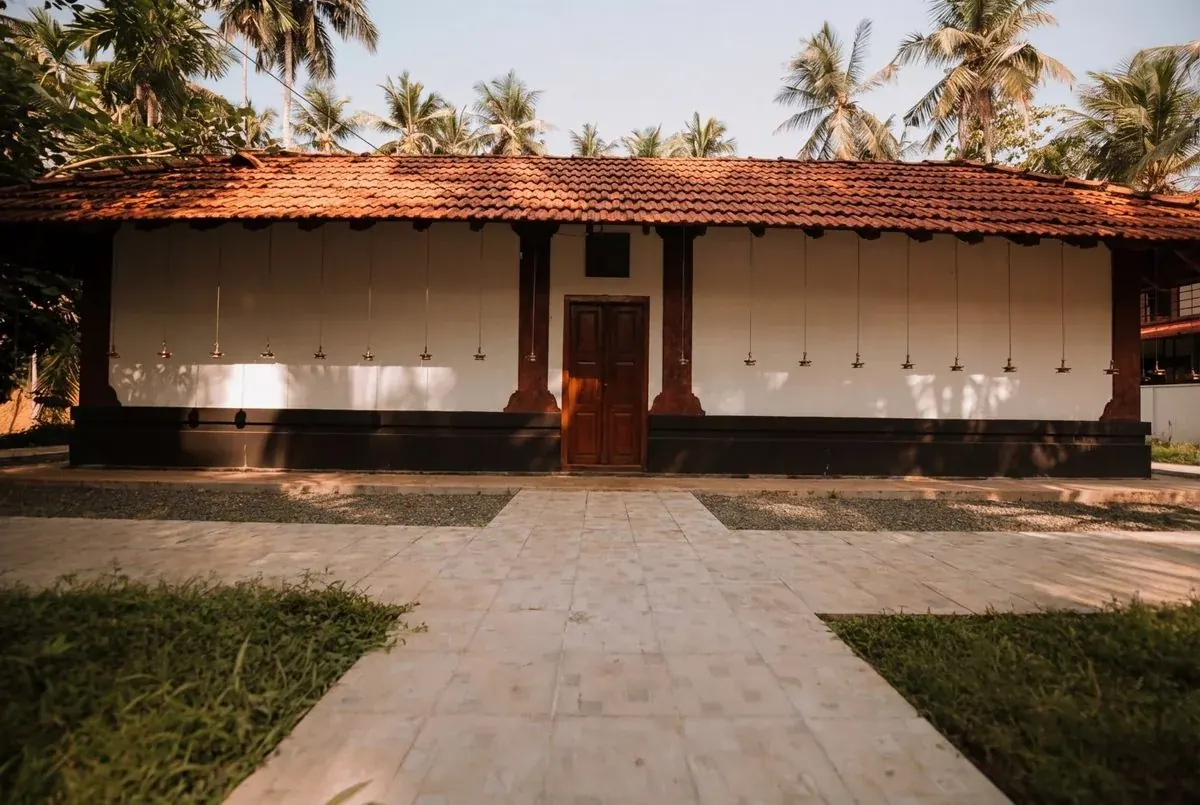 Front view of Kakkamvelly Sreekrishna Temple with Kerala-style tiled roof and hanging deepam lamps